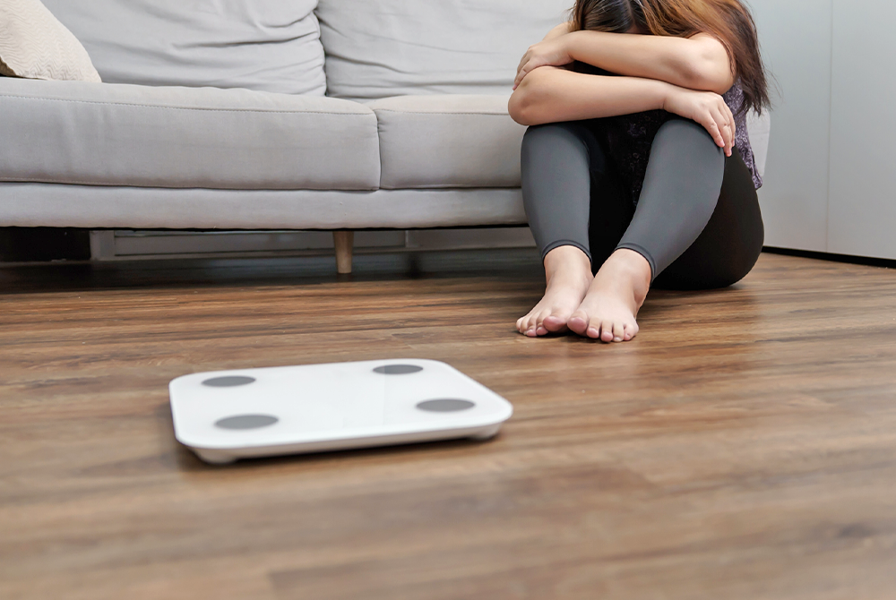 woman sitting next to scale